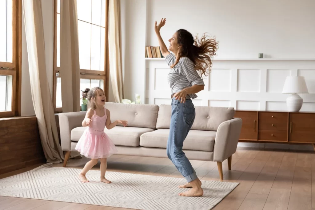 Mom and daughter playing and dancing energetically. 