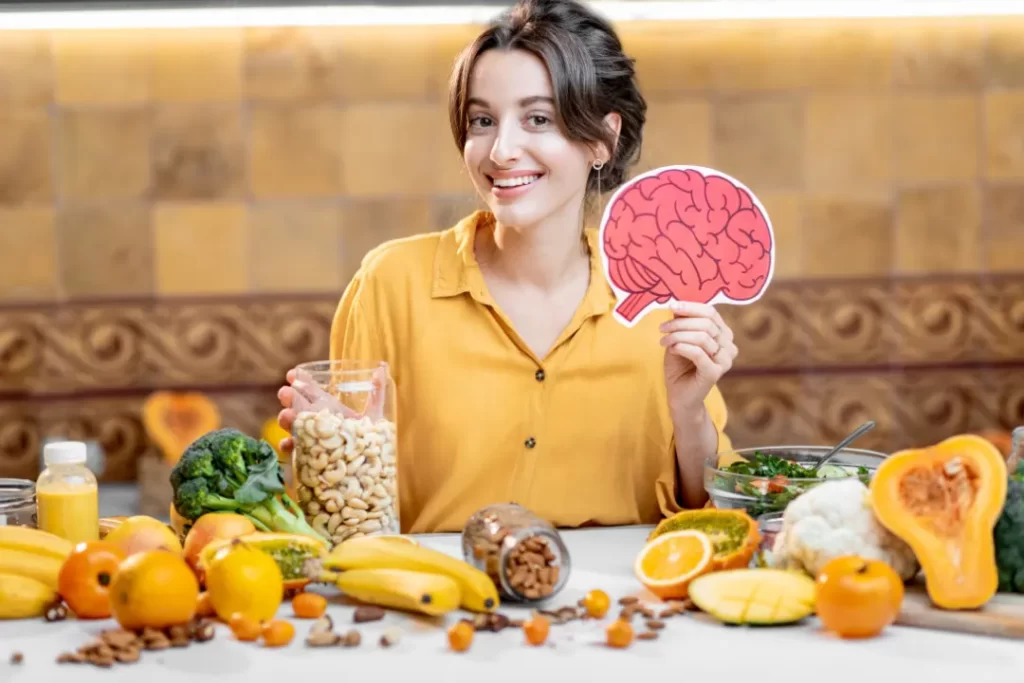 young attractive girl holding a Human Brain Model and a Variety of Healthy Fresh Food on table