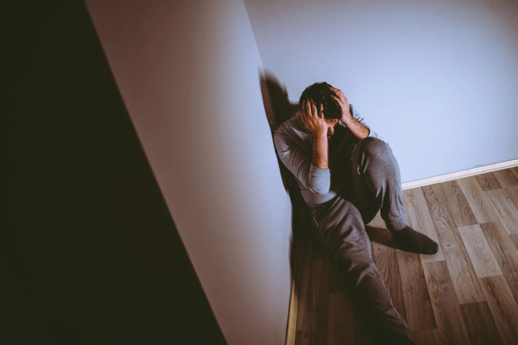 Young depressed man sitting on the floor.