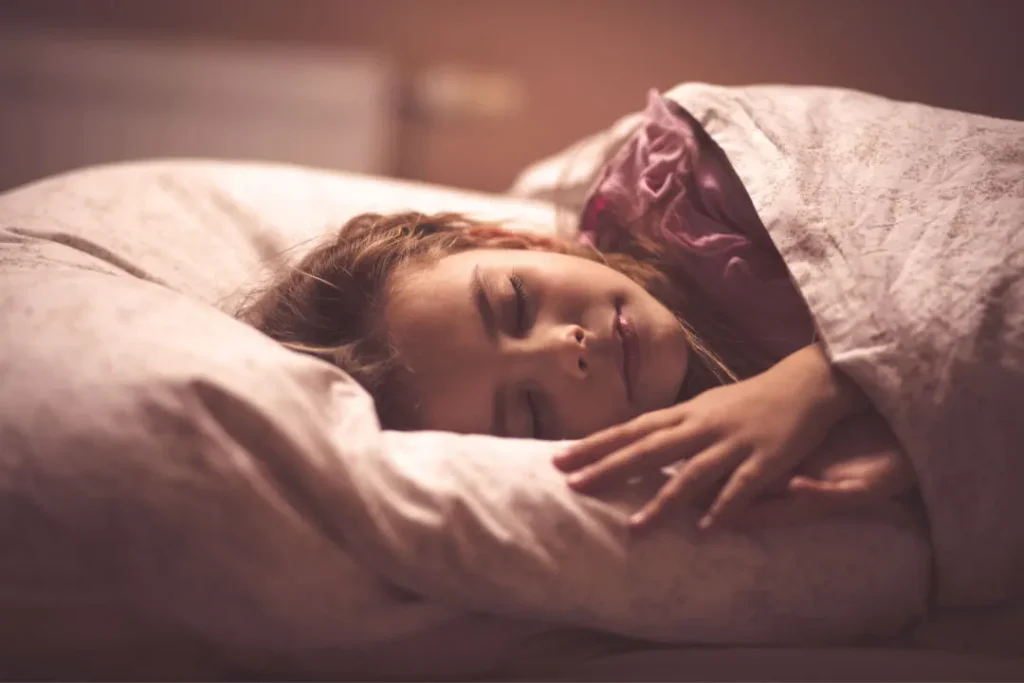 A child sleeping on bed. 