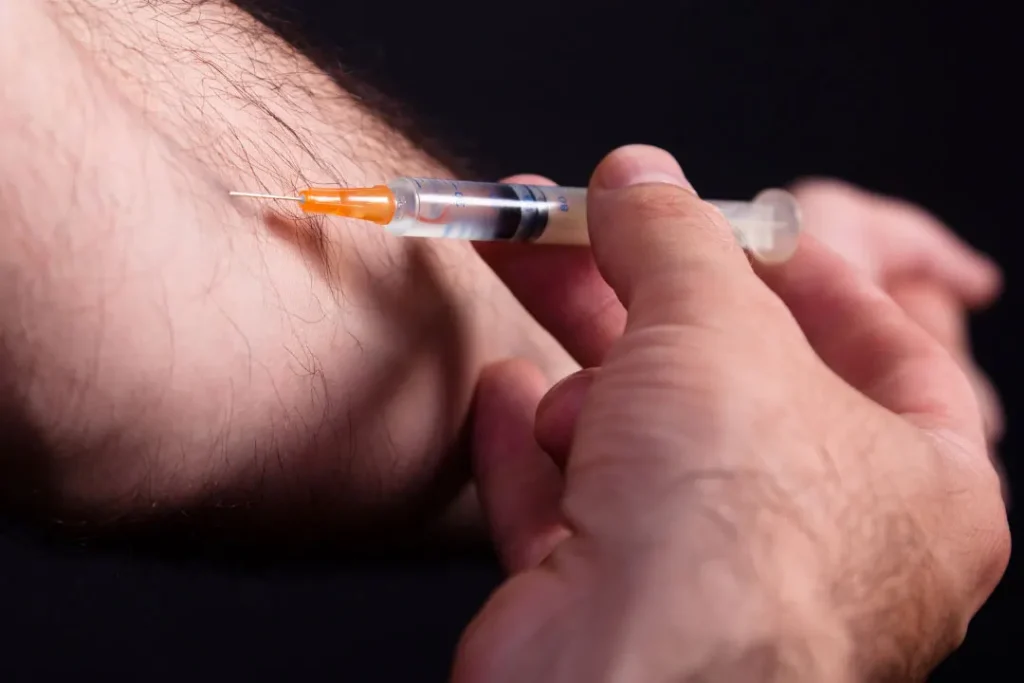 Young man taking drugs through injection