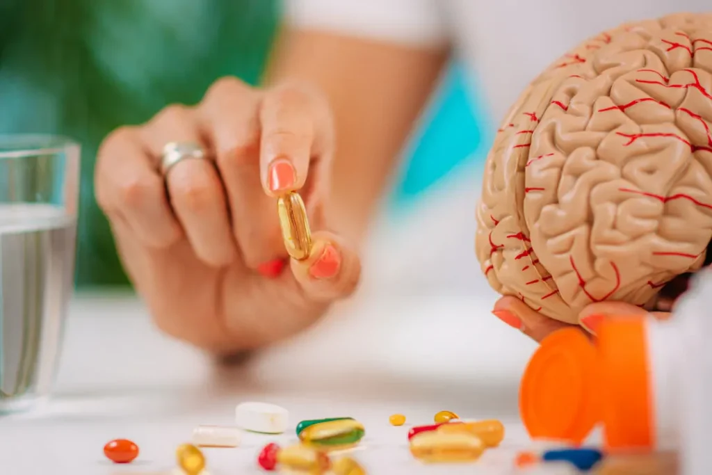 woman holding a pill and a brain model