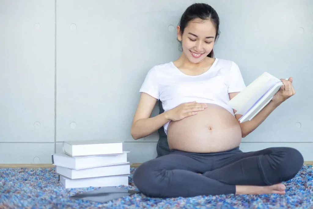 A pregnant lady reading books. 