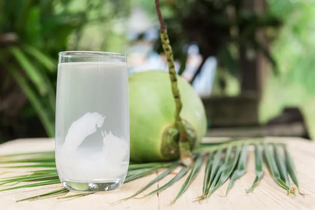 Coconut Water in glass and coconut on wooden table