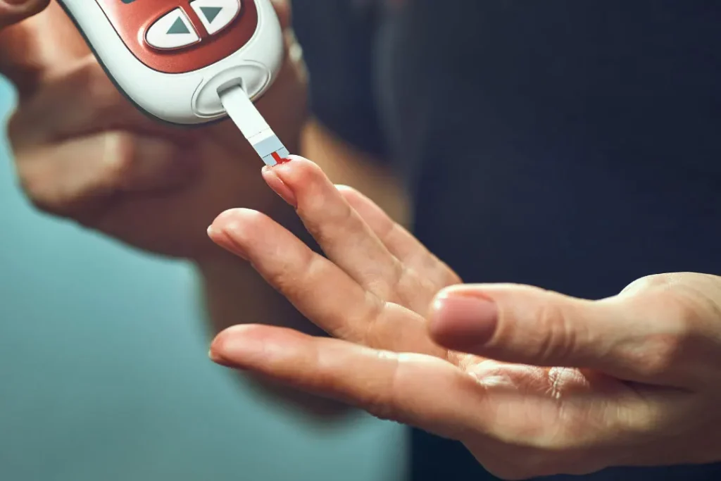 diabetic person using blood glucose meter