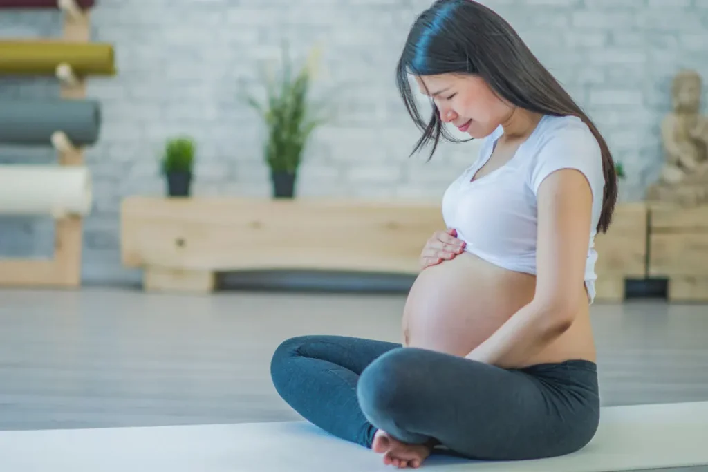 Pregnant lady sitting on ground. 