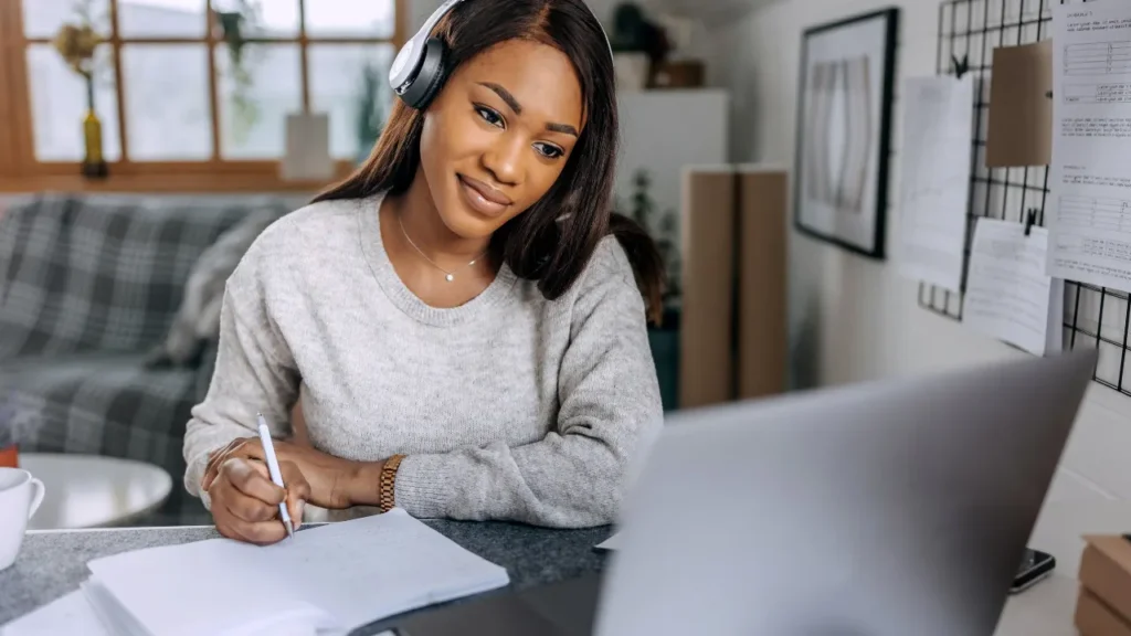 Lady is writing on the notebook. 