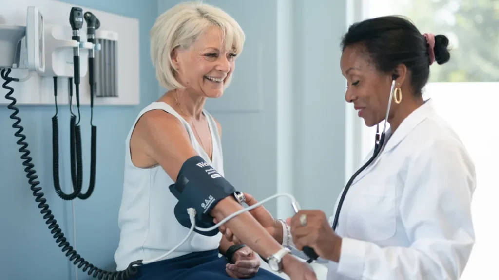 Doctor is checking blood pressure of her patient. 